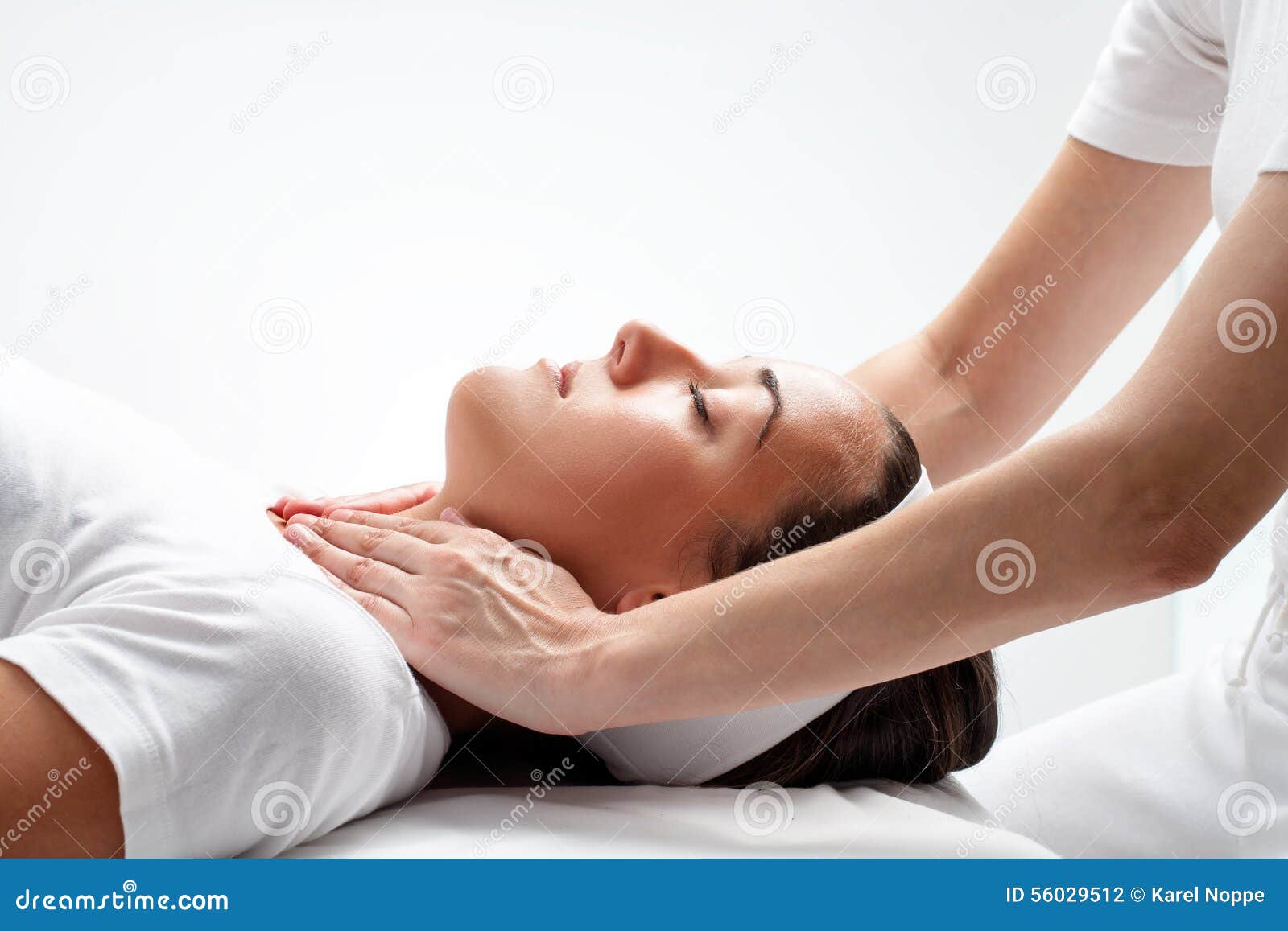 therapist doing reiki on womanÃ¢â¬â¢s neck.